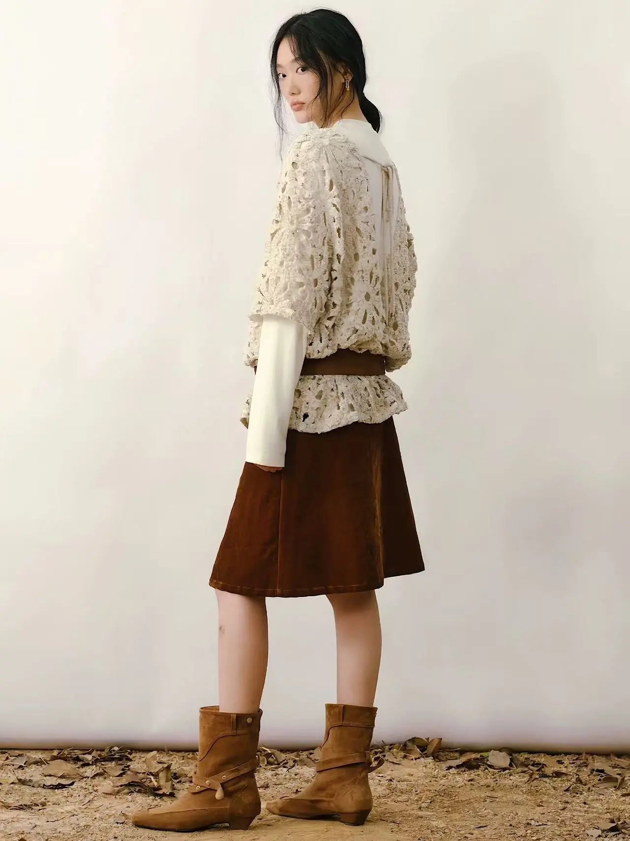 A woman wearing an embroidered down jacket in a snowy park setting, showcasing the artistic detail.