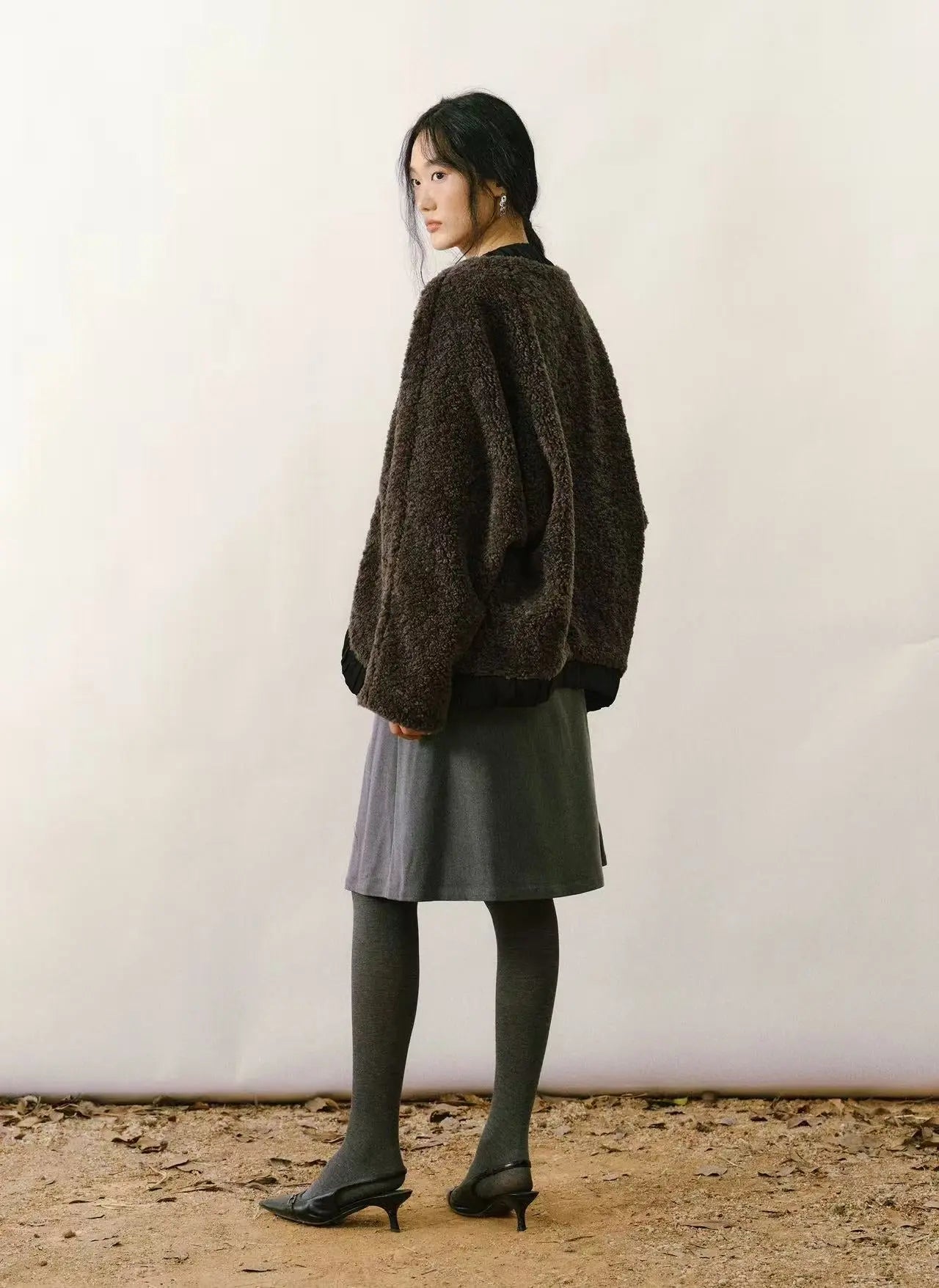 Tan faux shearling coat with cream-colored plush lining and large statement buttons on a white background.