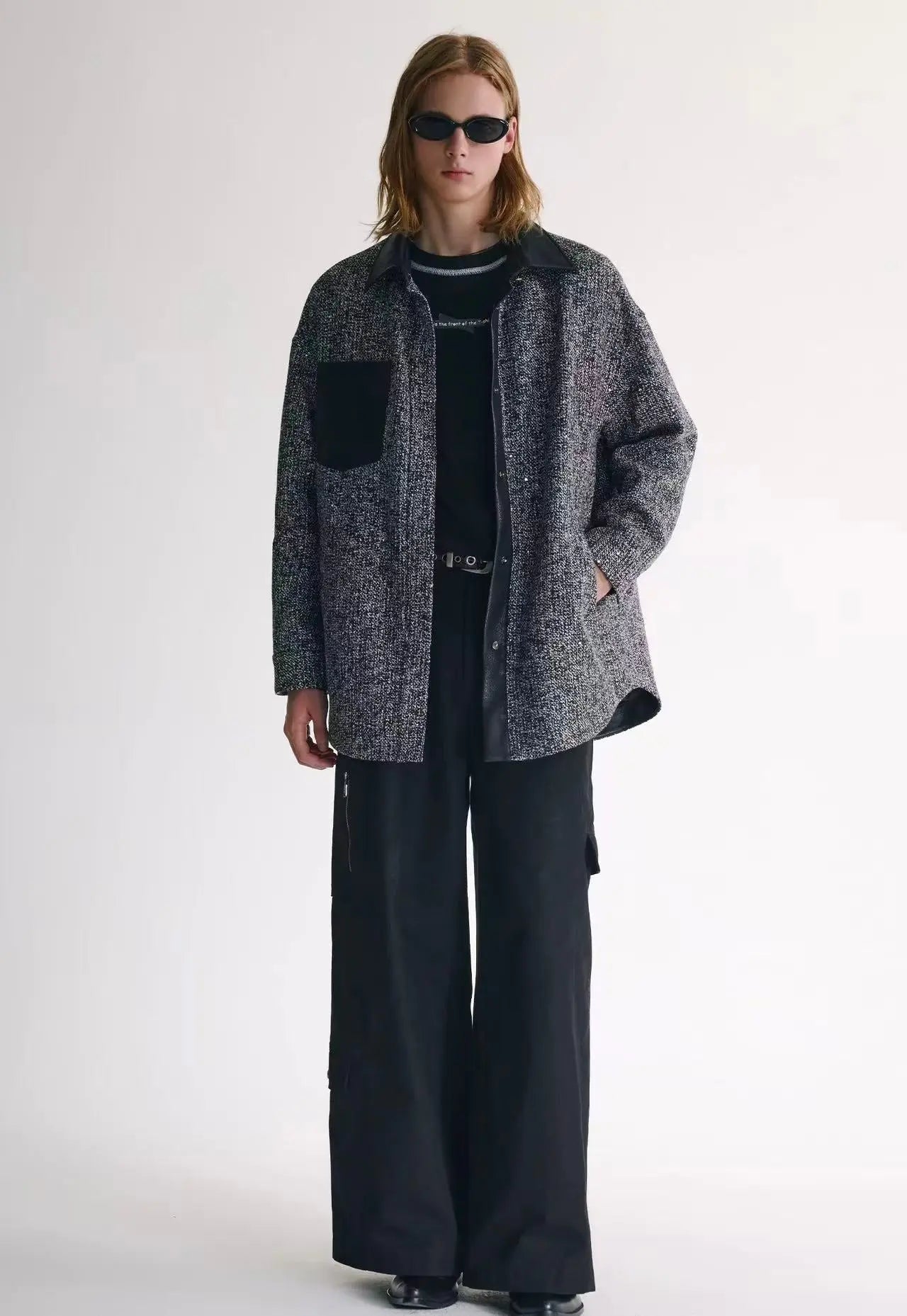 Man wearing a brown speckled tweed jacket over a turtleneck sweater while walking through an autumn park