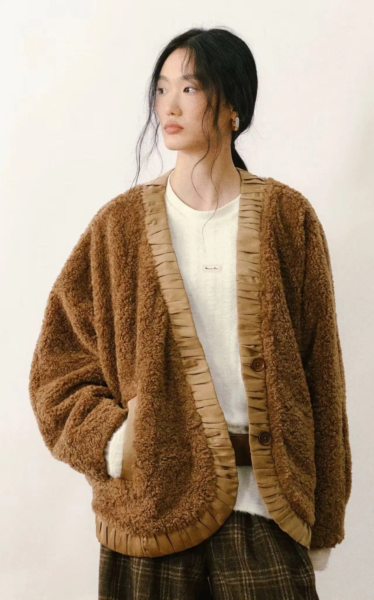 Tan faux shearling coat with cream-colored plush lining and large statement buttons on a white background.