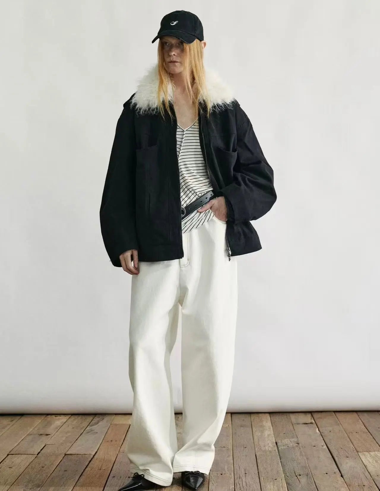 Full-length view of a navy blue down parka with a fur-trimmed hood and multiple utility pockets.